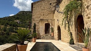 A stone building with a pool and potted plants. - Le Pallier + extension (DIO-ET-VALQUIERES)