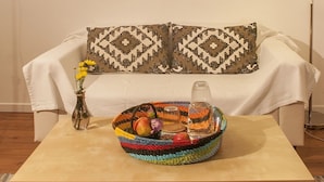 A room with a sofa, a coffee table, a lamp, and a window with blinds. - Inn Bairro Alto Bed & Breakfast (Lisbon)