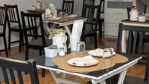 A dining area with a table set for two, featuring a white pitcher, a glass pitcher, and a salt and pepper shaker. - Inn Bairro Alto Bed & Breakfast (Lisbon)