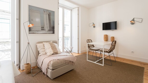 A modern bedroom with a bed, a desk, and a TV. - Chiado Studios By Lu Holidays (Lisbon)