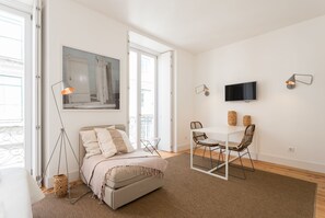 Ein modernes Schlafzimmer mit Bett, Schreibtisch und Fernseher.