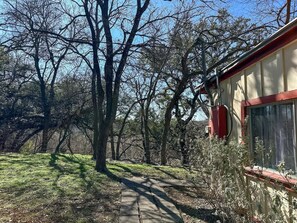 Un chemin menant à un bâtiment entouré d’arbres.