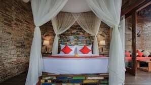 A bed with a white canopy and red pillows, set against a colorful mosaic wall. - Hideaway Villas Candy Ubud (Ubud)
