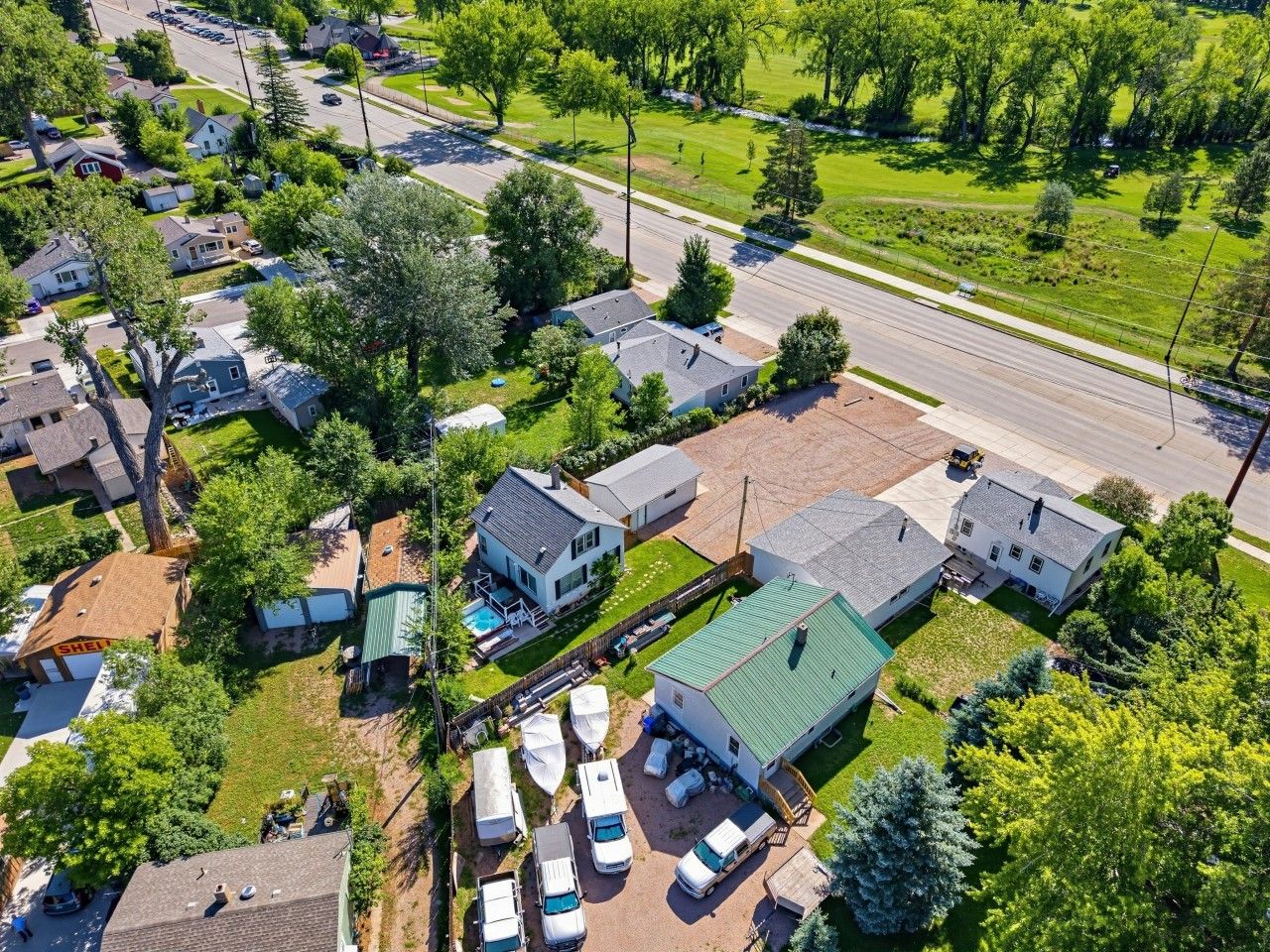 A residential area with houses, a road, and a green space.