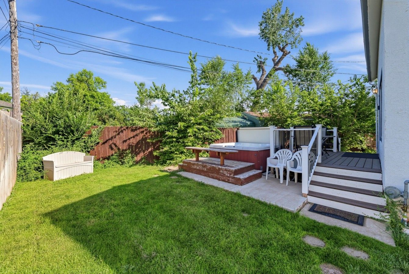 Ein Garten mit Terrasse, Sitzgelegenheit im Freien und einer Holzterrasse.