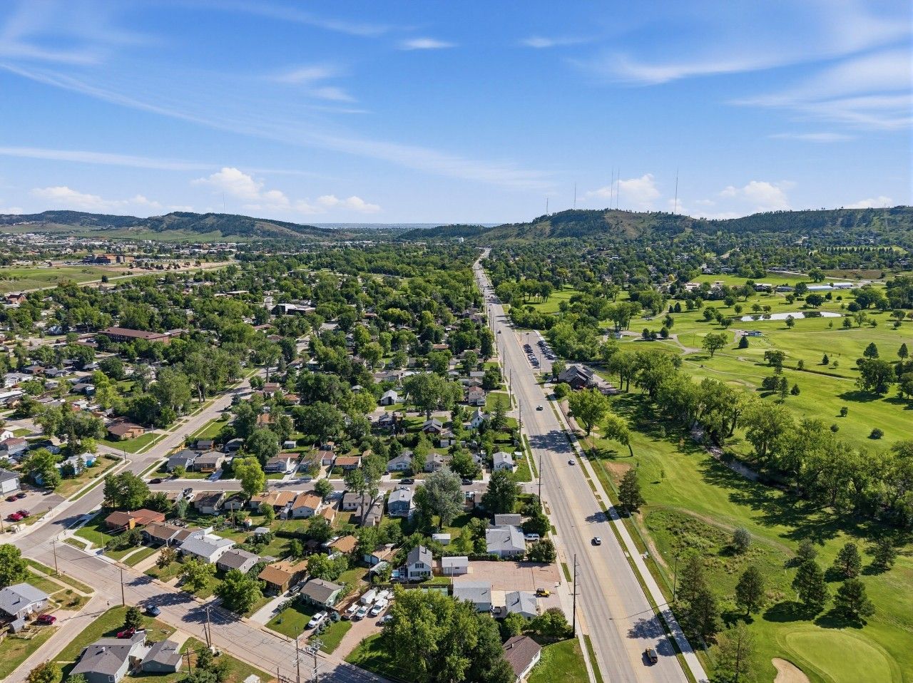 A residential area with houses, roads, and green spaces.