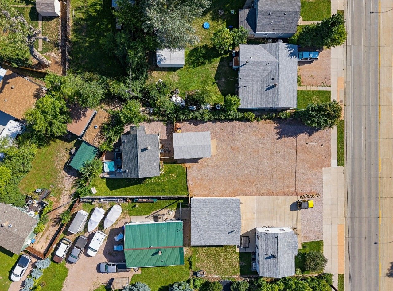 Vista aérea de un barrio residencial con varias casas, un estacionamiento y una calle.
