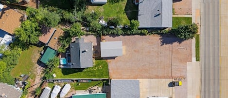 Vista aérea de un barrio residencial con varias casas, un estacionamiento y una calle.
