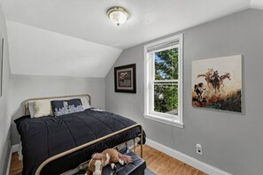 A bedroom with a bed, a window, and two wall-mounted artworks. - Cozy Rapid City Home w/ Hot Tub & Patio (Rapid City)
