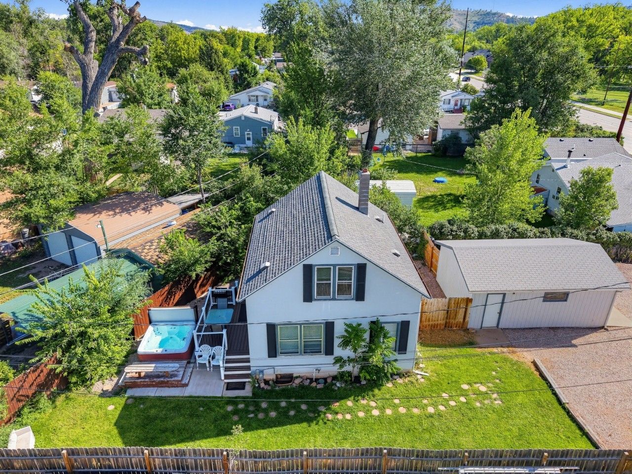 A residential property with a two-story house, a fenced backyard, and a swimming pool.