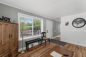 Une pièce comprenant un banc en bois, une horloge et un meuble.