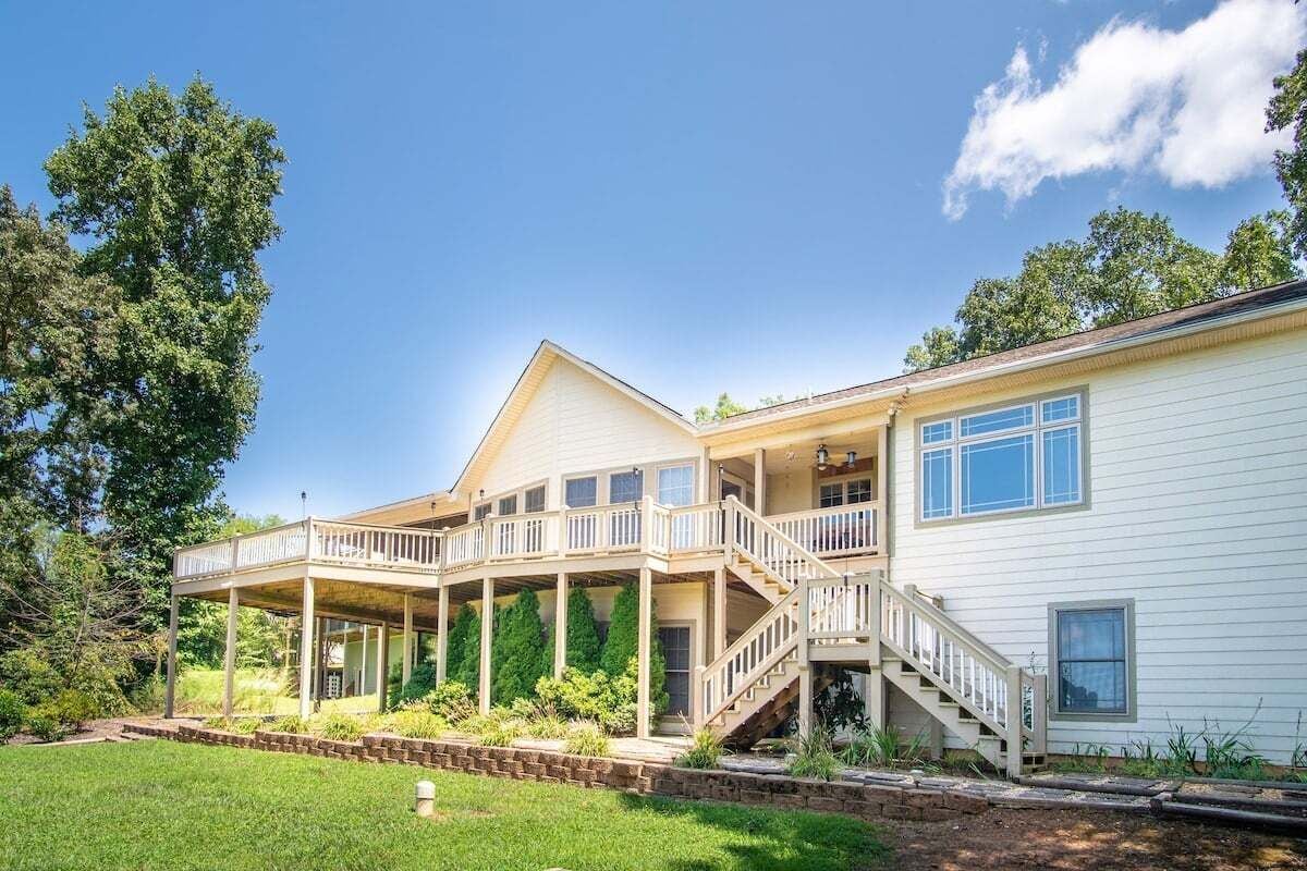 A two-story house with a covered porch, a staircase, and a well-maintained lawn.