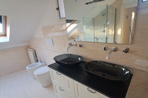 Ein modernes Badezimmer mit zwei Waschbecken, einer Toilette und einem Bidet.