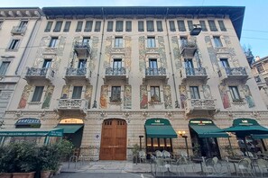 Ein historisches Gebäude mit aufwendigen Fassaden, mehreren Balkonen und Außenbereichen mit Sitzgelegenheiten.