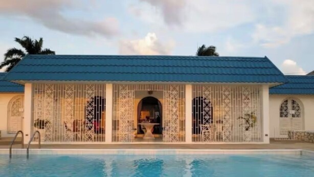 Una piscina con area coperta, caratterizzata da un tetto blu e cancelli in metallo decorativo.