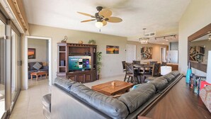 A modern living room with a leather sofa, wooden coffee table, and a TV on a wooden cabinet. - Ground Floor Oceanfront Sonoran Spa W105 (Puerto Peñasco)