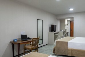 A hotel room with a desk, chair, laptop, TV, and two beds. - Rio Poty Hotel Sao Luis (São Luís)