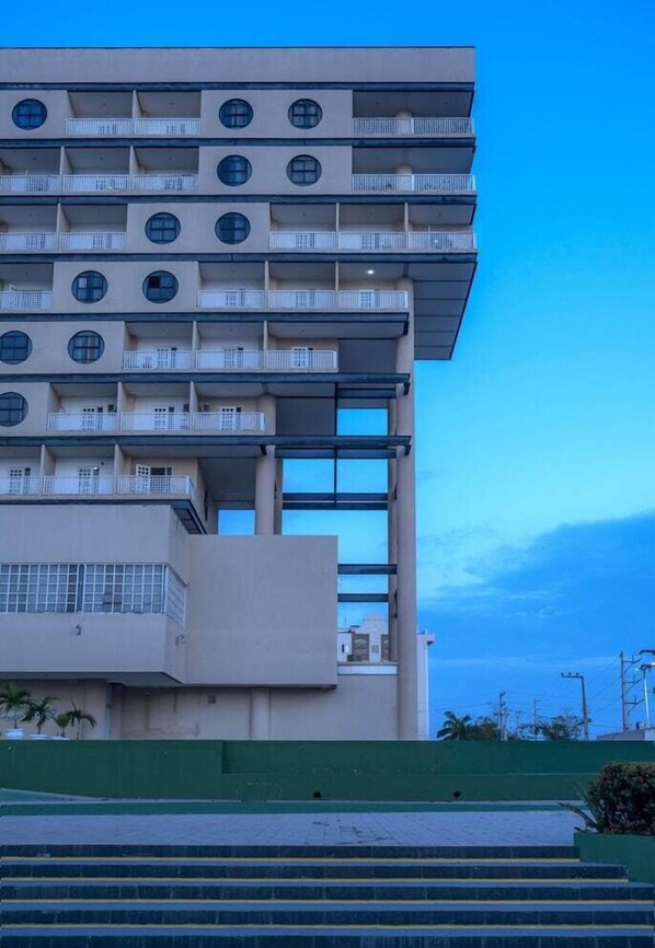Un edificio de varios pisos con balcones y ventanas amplias.