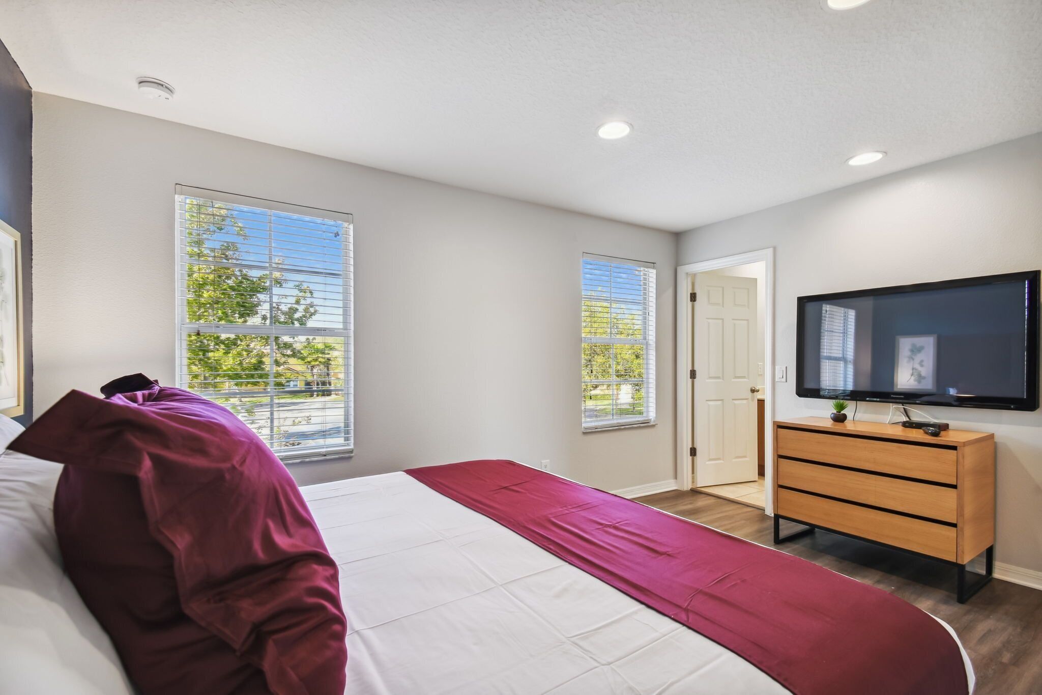 Une chambre à coucher avec un lit, une télévision et une commode.