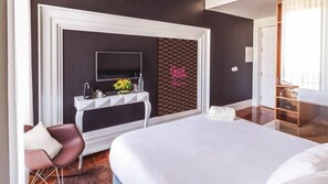 A modern hotel room with a large bed, a vanity with a mirror, a small table with toiletries, a decorative wall, and a view of the hallway. - RM Guest House The Experience (Setubal)