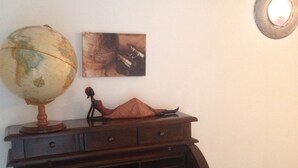 A wooden desk with drawers, a globe, a vintage camera, and a map on the wall. - Hotel de la Marne (Lyon)