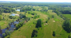 An aerial view of a golf course with multiple holes, water bodies, and dense forested areas. - Domaine DE LA Foret D Orient Natur Hotel Golf SPA (Rouilly-Sacey)