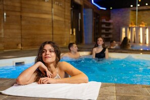 Un espace piscine doté d’un sol en bois et d’une table sur laquelle est posée une serviette blanche.