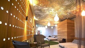 A spa room with wooden walls, a reception desk, and several beds. - Domaine de La Foret D Orient Natur Hotel Golf Spa (Rouilly-Sacey)