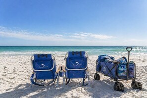 Two beach chairs and a luggage cart on a sandy beach with the ocean in the background. - Pool~Pet Friendly~5-Min Walk to Private Beach~2 Master Suites~Optional Golf Cart (Destin)