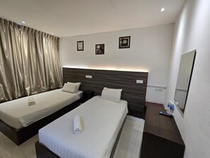 A hotel room with two single beds, a large mirror, and a small table with a water bottle. - One Point Hotel - RH Plaza (Kuching)