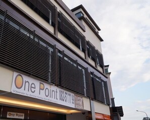 Ein modernes Gebäude mit einem Schild für 'One Point' und einer Kontaktnummer.