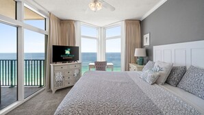A bedroom with a large bed, a TV, a ceiling fan, and a view of the ocean. - Must See ! Beach Front~ 2 King Mstrs +2 Q Bdrm ~ Fantastic Views! (Destin)