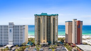 A hotel with a central tower, a shorter building to the left, and a taller building to the right, all with a view of the beach and ocean. - Upscale Condo with 2 King Master Suites and a 2-Queen Suite~ Wow Views! (Destin)