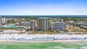 A coastal hotel complex with multiple high-rise buildings, a beach with numerous umbrellas, and a view of the ocean. - Upscale Condo with 2 King Master Suites and a 2-Queen Suite~ Wow Views! (Destin)