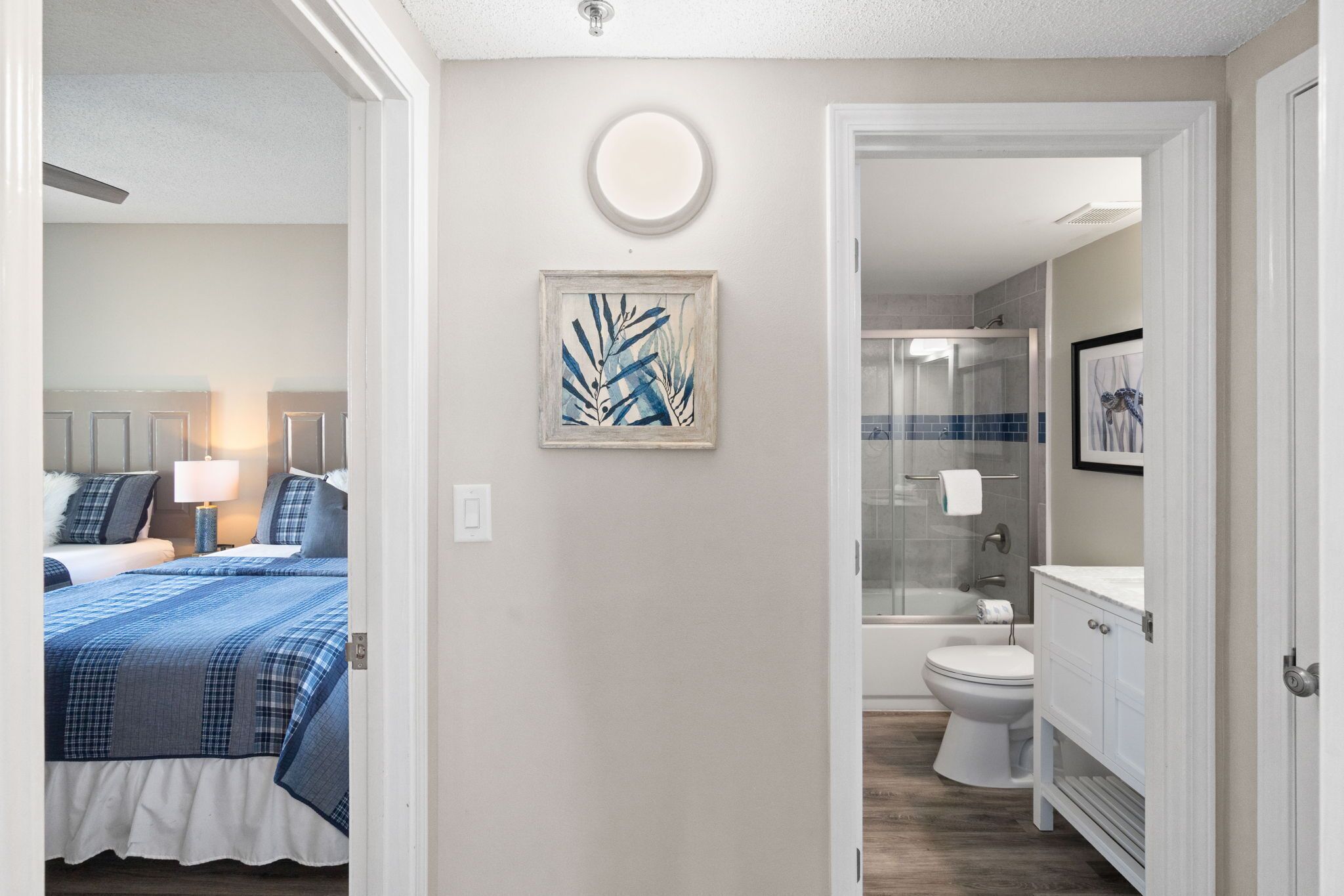 A bedroom with a bed, bedside table, and a wall-mounted light fixture.