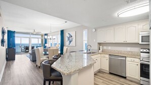 A modern kitchen with a granite countertop, stainless steel appliances, and a view to the outside. - Upscale Condo with 2 King Master Suites and a 2-Queen Suite~ Wow Views! (Destin)