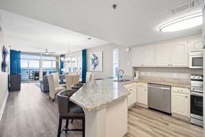 A modern kitchen with a granite countertop, stainless steel appliances, and a view to the outside. - Upscale Condo with 2 King Master Suites and a 2-Queen Suite~ Wow Views! (Destin)