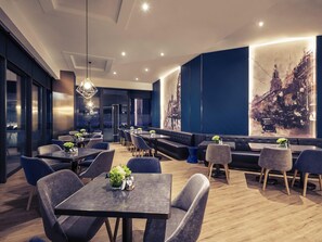 A modern restaurant with tables, chairs, and a large wall mural. - Mercure Shanghai Necc (Shanghai)