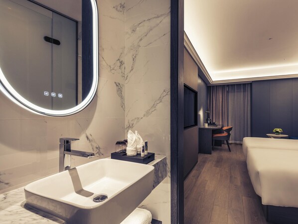 Un bagno moderno con un lavandino in marmo, uno specchio e una doccia.