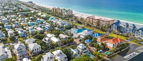 A coastal residential area with beachfront properties, a hotel with a pool, and a clear view of the ocean.