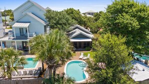 A residential property with a swimming pool, a covered patio, and a large house. - Private Pool, Steps to Beach, Screen in Porch, Cutest Cottage in Crystal Beach! (Destin)