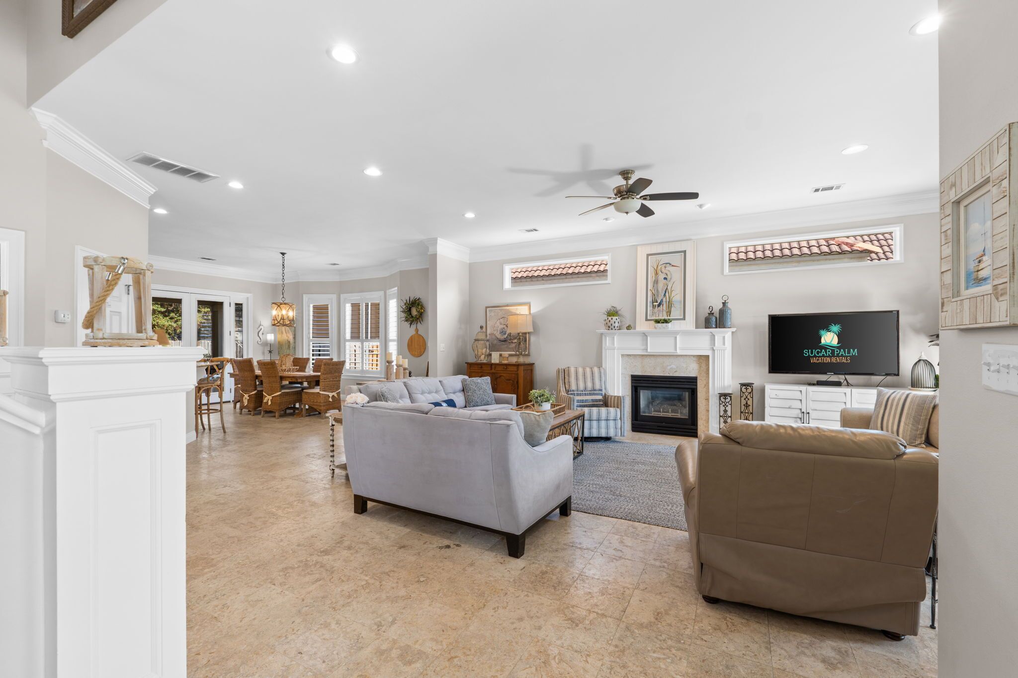 A spacious living room with a fireplace, a television, and a dining area with a chandelier.