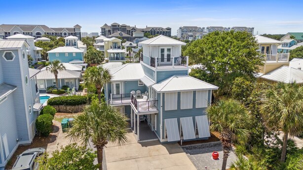 A coastal residential area with multiple two-story houses, each featuring a balcony and a small front yard. - Steps to Beach~Private Pool~Pet Friendly~Carriage House~Optional Golf Cart! (Destin)