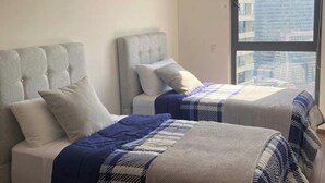 Two beds with headboards, a window with a city view, and a plain wall. - Polanco be grand (Ciudad de México)