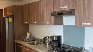 A modern kitchen with wooden cabinets, stainless steel appliances, and a granite countertop. - Polanco be grand (Ciudad de México)