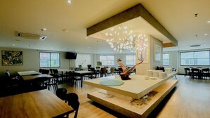 Une salle de conférence spacieuse, dotée d’un îlot central, de plusieurs tables et de chaises disposées pour les réunions.