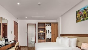 Habitació d'hotel amb llit, escriptori i armari.