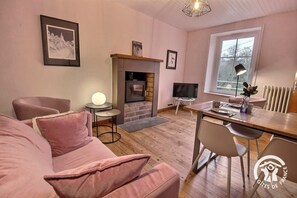 Una sala de estar acogedora con chimenea, televisor y zona de comedor.