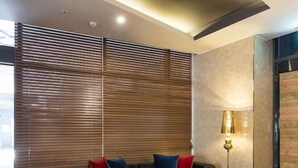A modern living room with a sectional sofa, a glass coffee table, and a floor lamp. - Guseo Station Brown Dot (Busan)