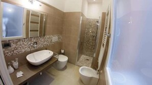 A bathroom with a large sink, toilet, and shower area. - B&B Chez Moi (Bologna)